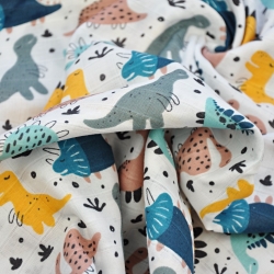 Baumwoll-Musselin mit bunten Dinosauriern auf weißem Hintergrund  