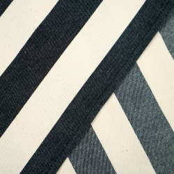 Liegegewebe mit schwarzen Streifen auf ecrufarbenem Hintergrund