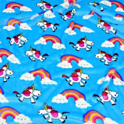 Kuschelfleece Stoff – Kinder Muster -  Einhörner mit Regenbogen auf blauem Hintergrund